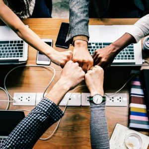 A group of business people bumping fists together over a table